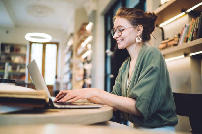 Femme freelance souriante sur son ordinateur
